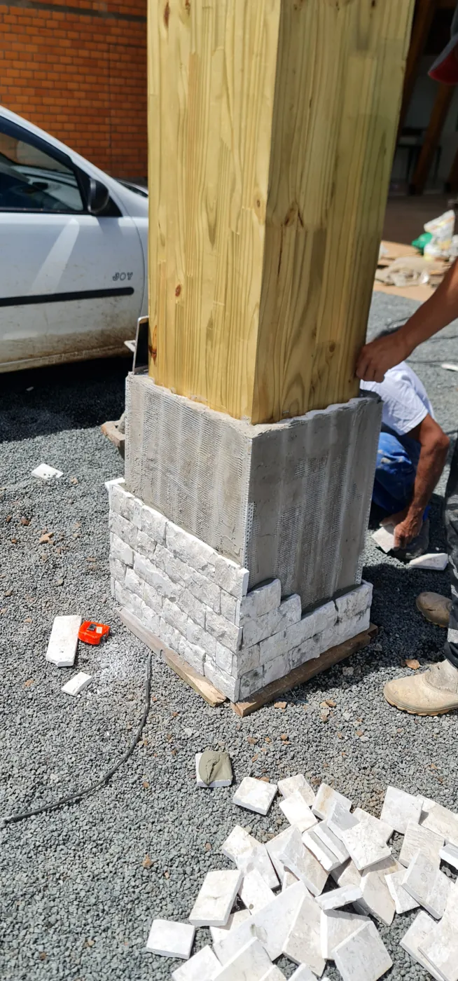 Pilar de MLC apoiado em base de alvenaria durante a obra